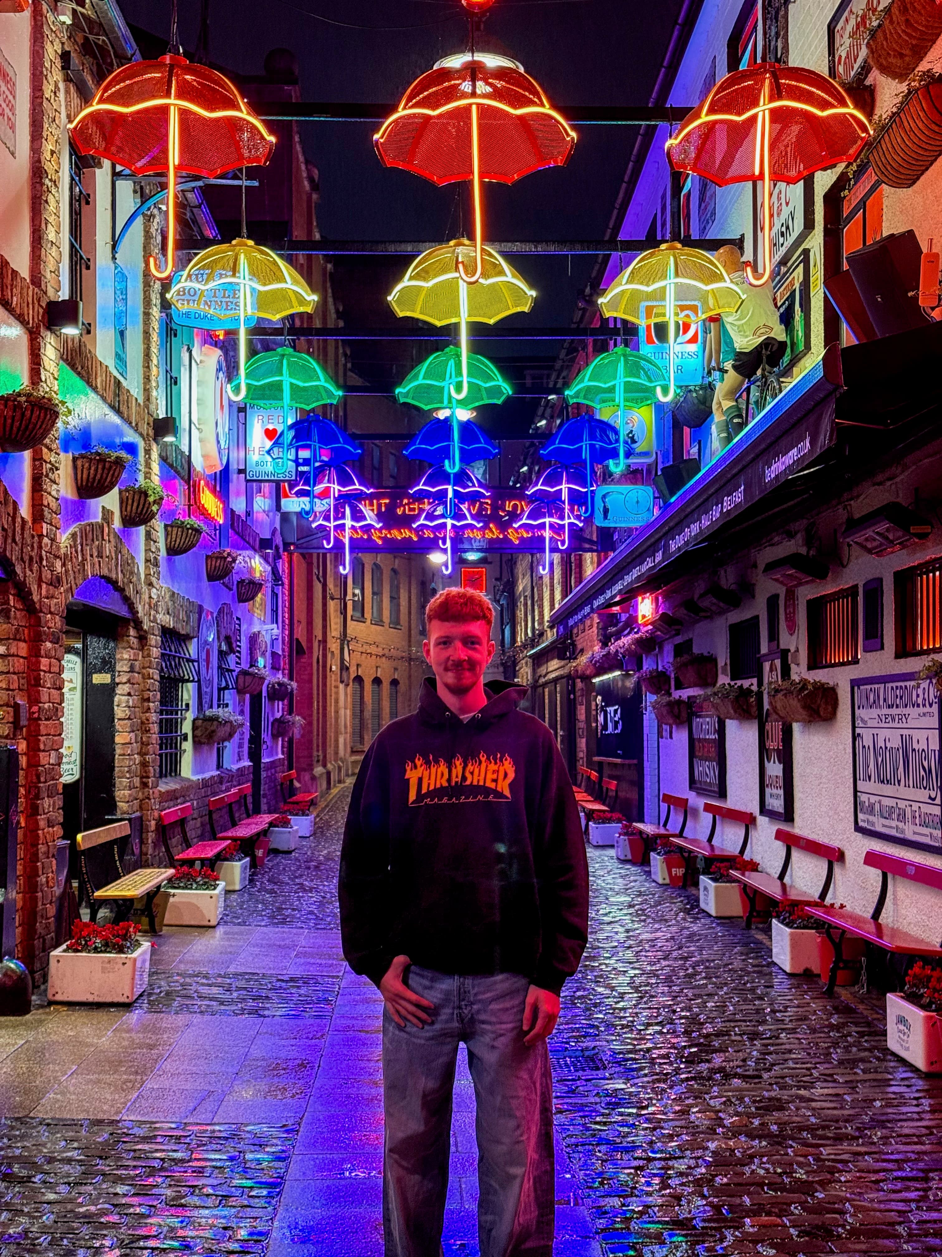 Chris McClair standing under colorful umbrella lights